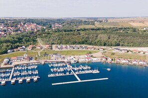 Luftaufnahme eines Yachthafens mit zahlreichen dort liegenden Booten, umgeben von Wohngebäuden und Grünflächen.