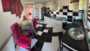 Une cuisine moderne avec un carrelage à motifs, une table à manger avec des chaises et un évier.
