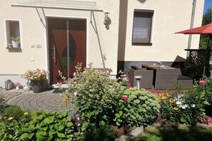 A house with a patio area, outdoor seating, and a variety of potted plants. - "At the castle park" (Bertsdorf-Hörnitz)