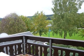 Ein Balkon mit Blick auf eine grüne Landschaft und Bäume.