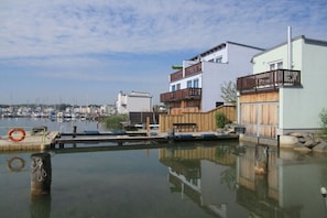 A waterfront property with a dock, a wooden fence, and a building with a balcony. - Anglers directly at Lake Hainer (Neukieritzsch)