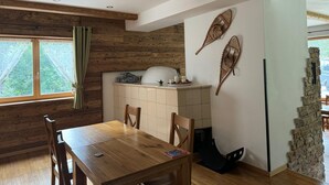 Un comedor con una mesa y sillas de madera, una ventana con cortinas y una pared con detalles decorativos.