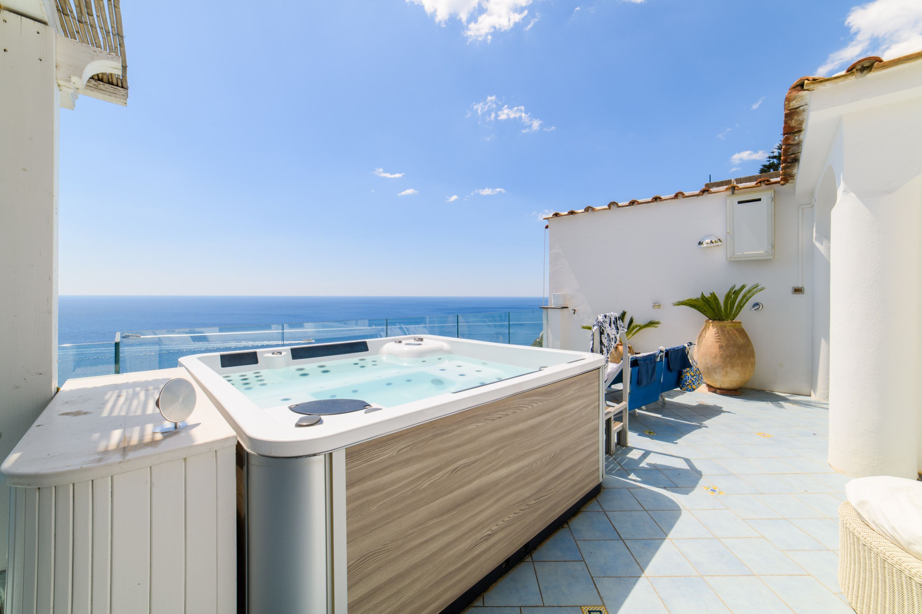 Un jacuzzi en un balcón con vistas al mar.