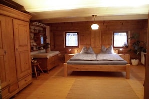 Ein Zimmer aus Holz mit einem Bett, einem Schreibtisch und einem Schrank.