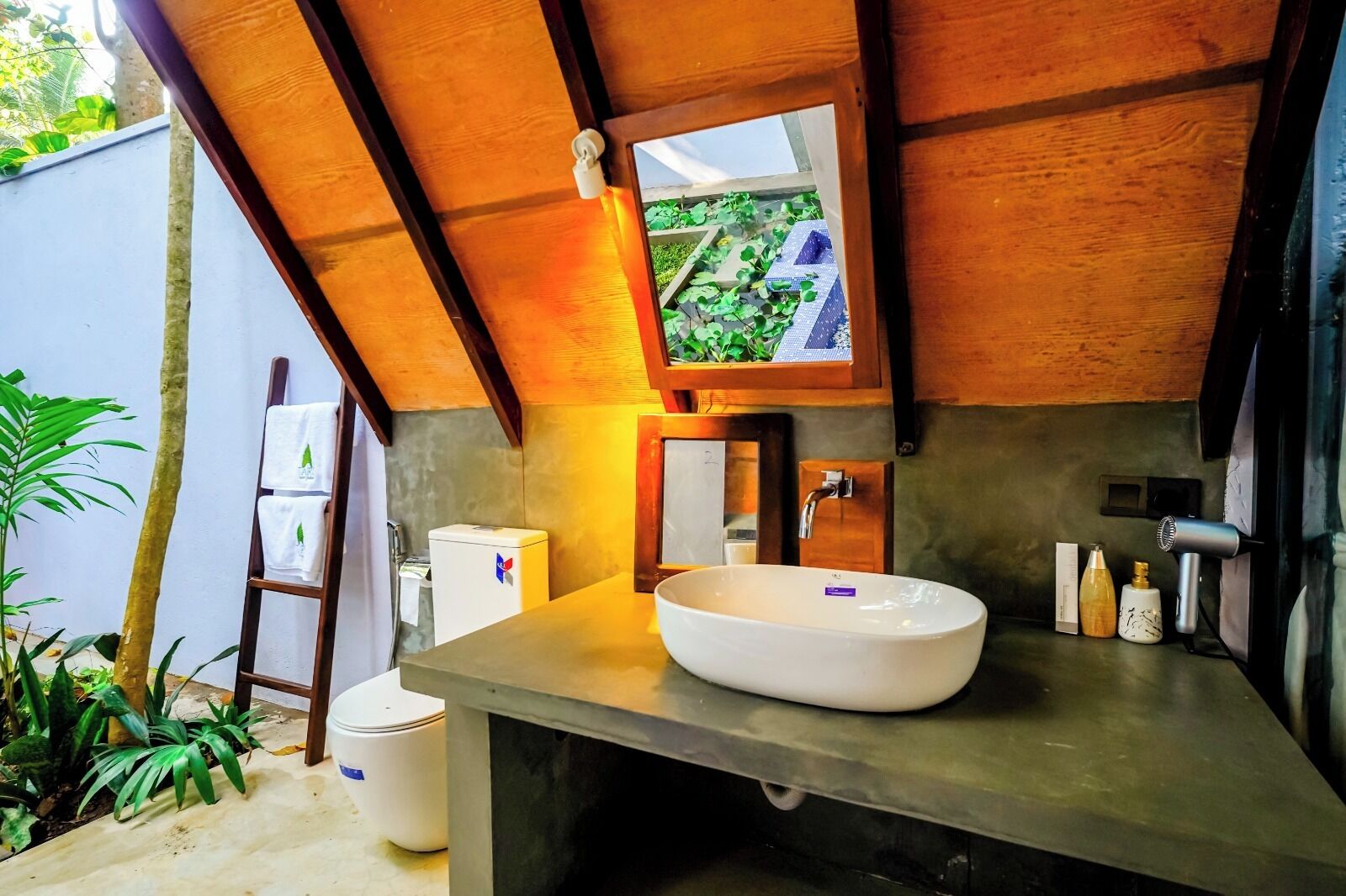 A bathroom with a large white sink, a mirror, and a towel rack.