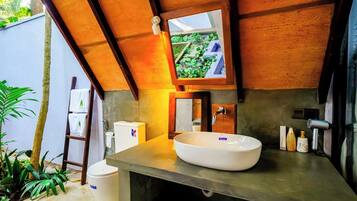 A bathroom with a large white sink, a mirror, and a towel rack.