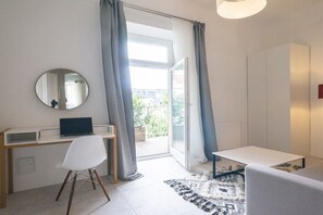 Ein modernes Zimmer mit Schreibtisch, Stuhl und einem großen Spiegel.