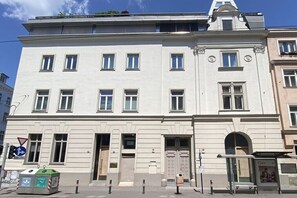 A multi-story building with a symmetrical facade, large windows, and a central entrance. - tastefully decorated and quiet with a terrace (Wien)