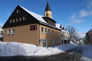 Ein Gebäude mit steilem Dach, einem Turm und einem Schild, das ein Restaurant anzeigt.