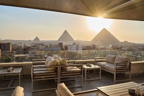 A rooftop terrace with seating and a view of the pyramids. - Kemet Pyramids View Hotel (Giza)