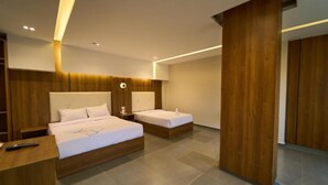 A modern hotel room with two beds, wooden headboards, a nightstand, and a large wooden pillar. - Kemet Pyramids View Hotel (Giza)