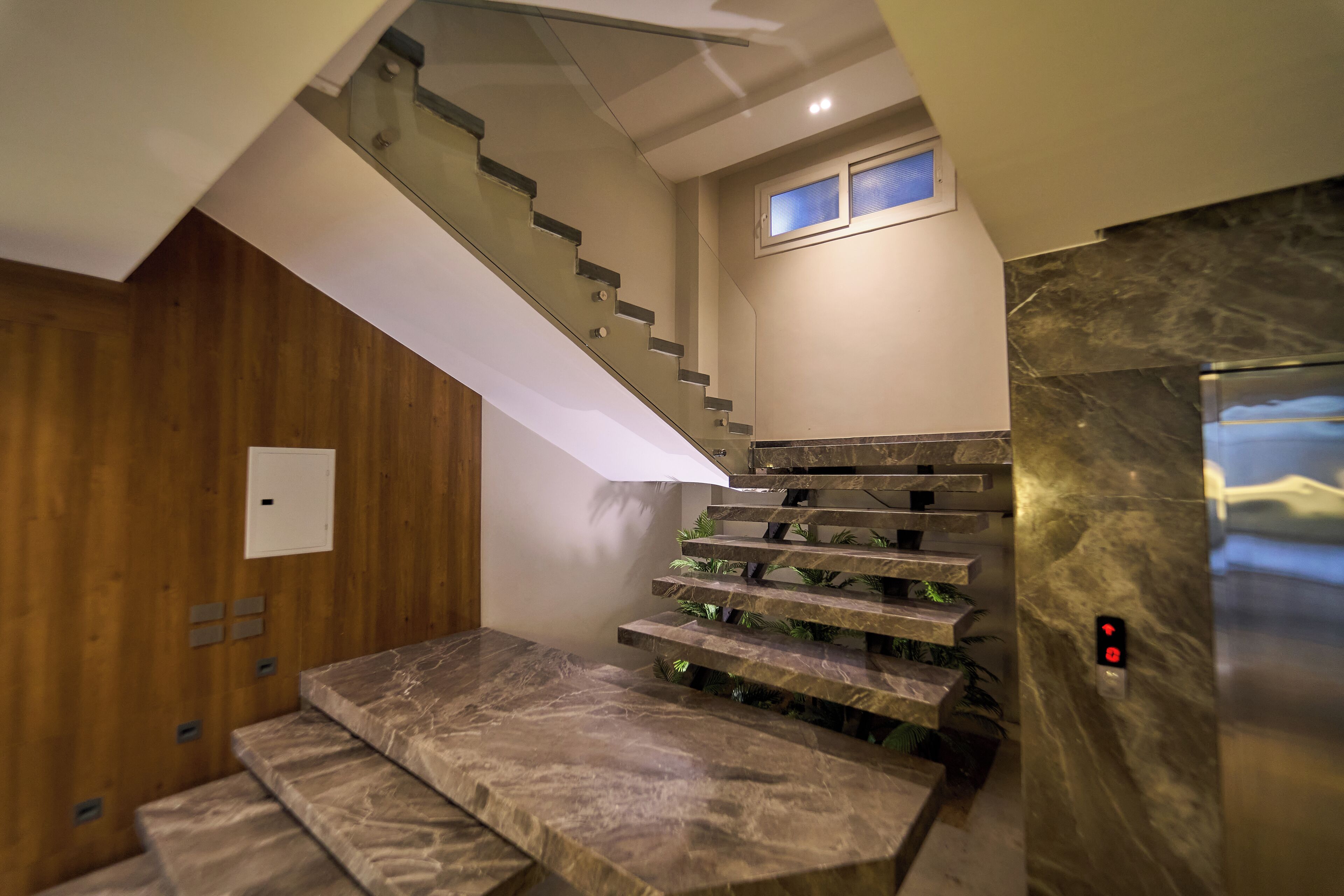 A modern staircase with marble steps and a wooden wall.