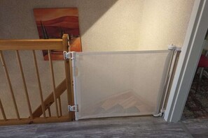 Una habitació amb una porta de fusta, un quadre a la paret i un sòl amb moqueta.