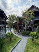 Un patio con piscina, una escalera y edificios de estilo tradicional.