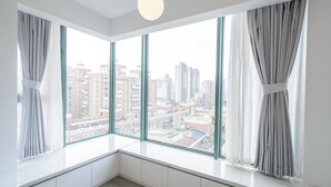 A room with large windows, a white ceiling, and a hanging light fixture. - Tyms 3BR 2BA Family Serviced Apt (Shanghai)