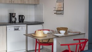 A compact kitchen with a coffee maker, a small refrigerator, and a dining area with a table, chairs, and a basket. - Chalet with On-Site Fitness Room (Fabrègues)