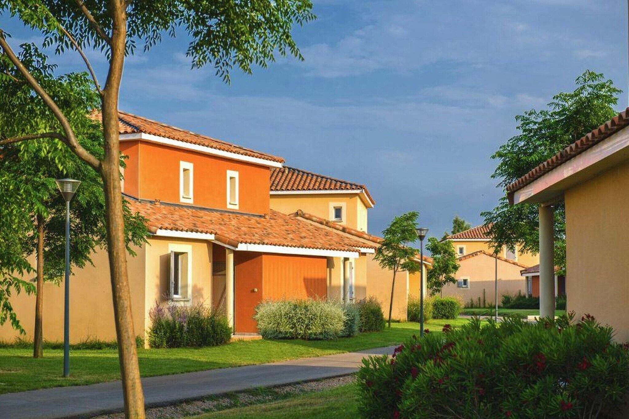 A residential area with houses, a paved path, and greenery.