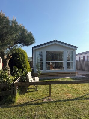 A small, single-story house with a gabled roof, large windows, and a front porch. - Chalet 193 (for 4 persons) (Petten)