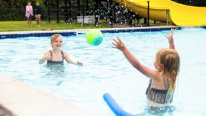 A swimming pool with a yellow slide in the background. - Chalet 193 (for 4 persons) (Petten)