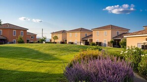 A row of uniform houses with a well-maintained lawn and lavender bushes. - French Villa with Shared Pool (Fabrègues)