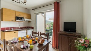 Eine moderne Küche mit Essbereich, einem Fernseher und einem Balkon mit Blick.