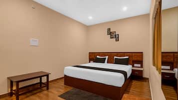 A hotel room with a bed, bedside tables, a bench, and a rug.