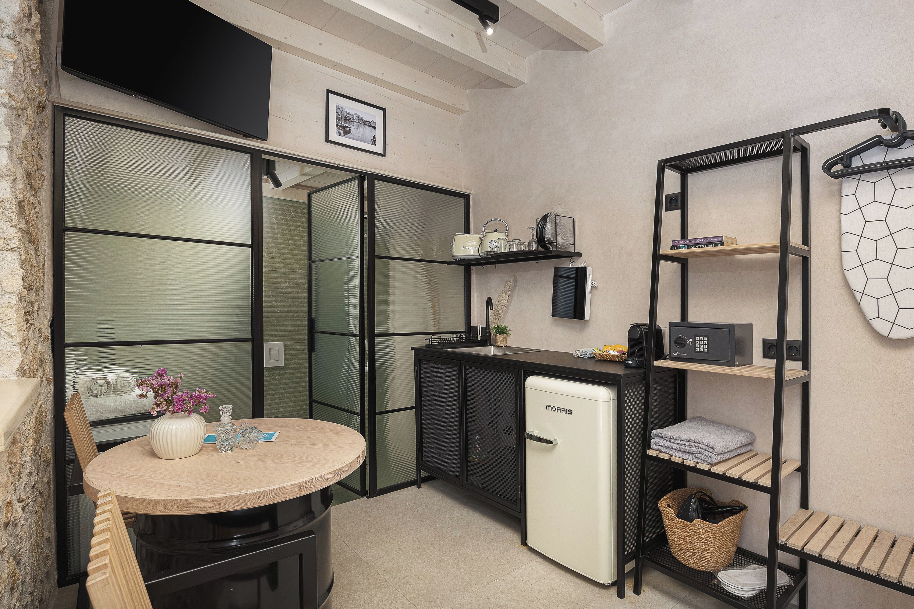 A compact kitchen with a refrigerator, a sink, and a small dining table.