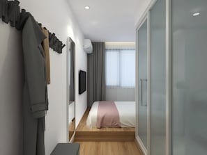 A modern hotel room with a bed, a TV, a wardrobe, and a sliding door. - Happy Dragon Alley Hotel-Forbidden City (Beijing)