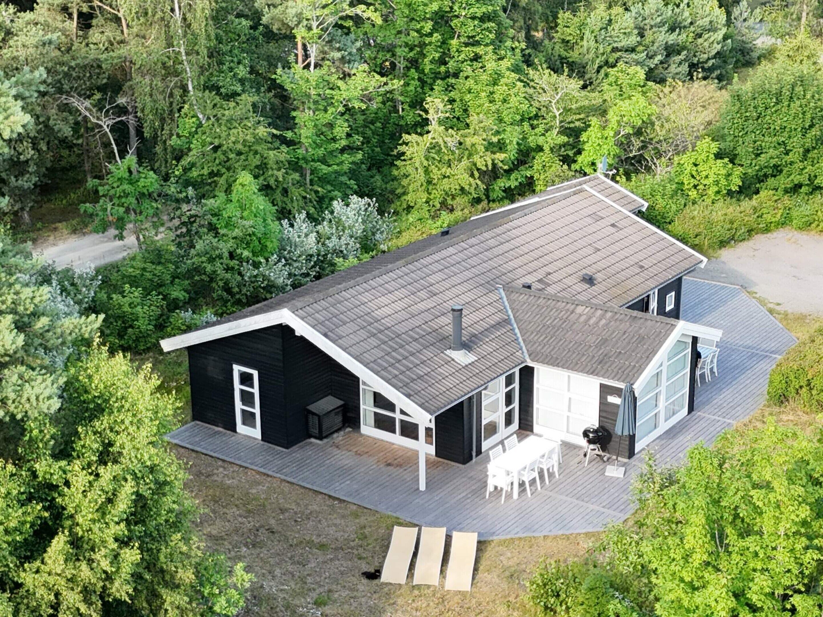 Uma casa moderna com um deck amplo, uma garagem e área de estar coberta ao ar livre.