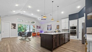 A spacious kitchen with a central island, modern appliances, and pendant lighting. - Resort-style outdoor living paired with comfort, style, and relaxation (Atascocita)