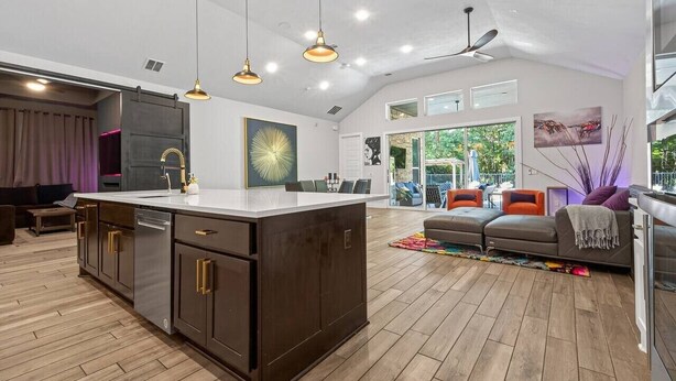 A spacious living area with a large kitchen island, pendant lighting, and a view of the outdoors. - Resort-style outdoor living paired with comfort, style, and relaxation (Atascocita)