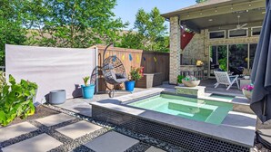 A backyard with a swimming pool, outdoor seating, and a covered patio area. - Resort-style outdoor living paired with comfort, style, and relaxation (Atascocita)