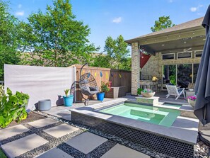 A backyard with a swimming pool, outdoor seating, and a covered patio area. - Resort-style outdoor living paired with comfort, style, and relaxation (Atascocita)