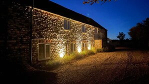 A stone building with a brick facade, a paved driveway, and a clear sky.