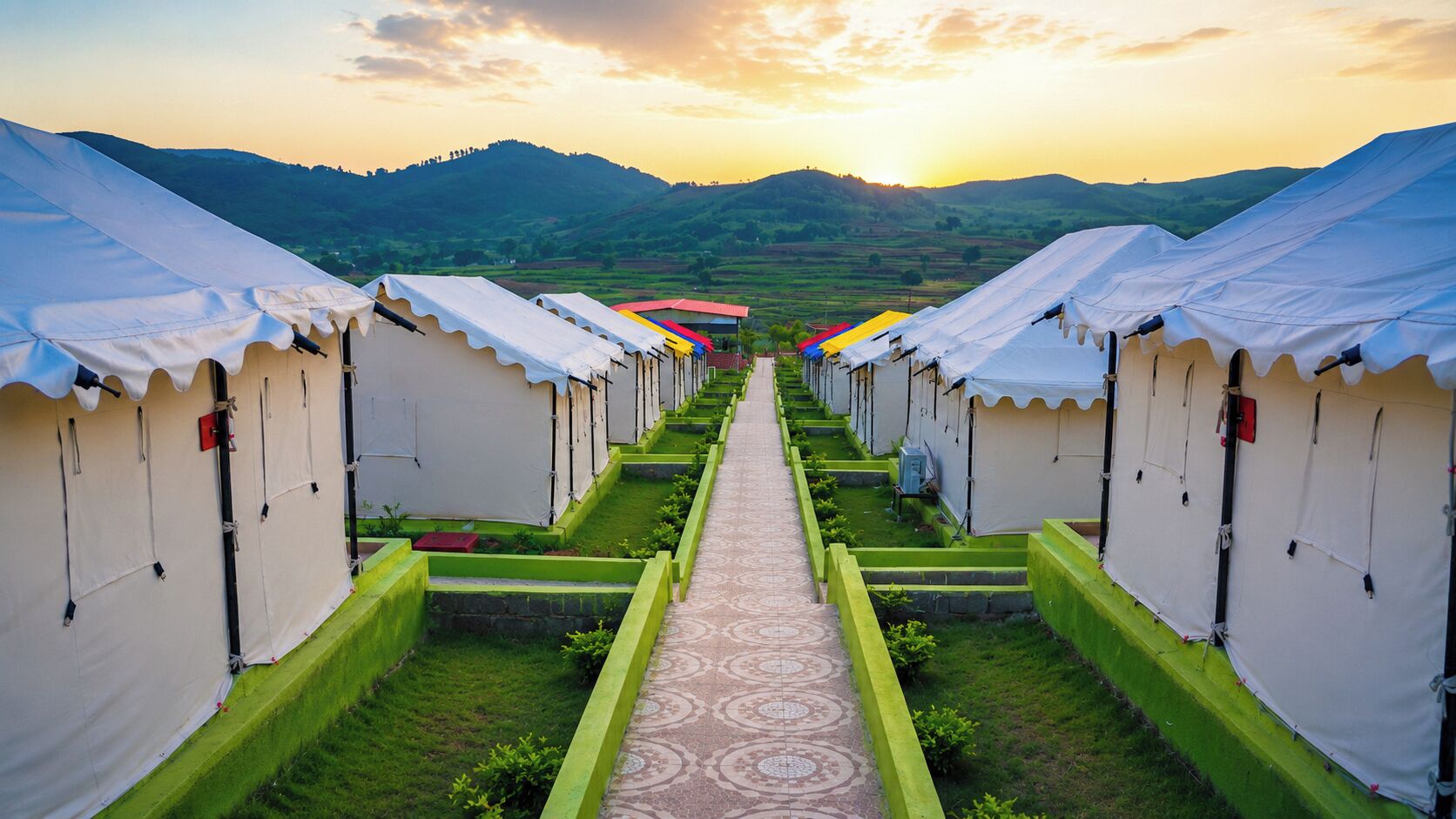A row of white tents with green bases, arranged in a pathway leading to a distant red structure.