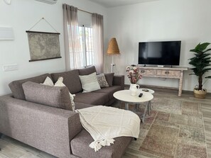 A living room with a sofa, a coffee table, a television, and a potted plant. - Newly renovated single-story house, a 6-minute walk to Los Locos Beach. (Torrevieja)