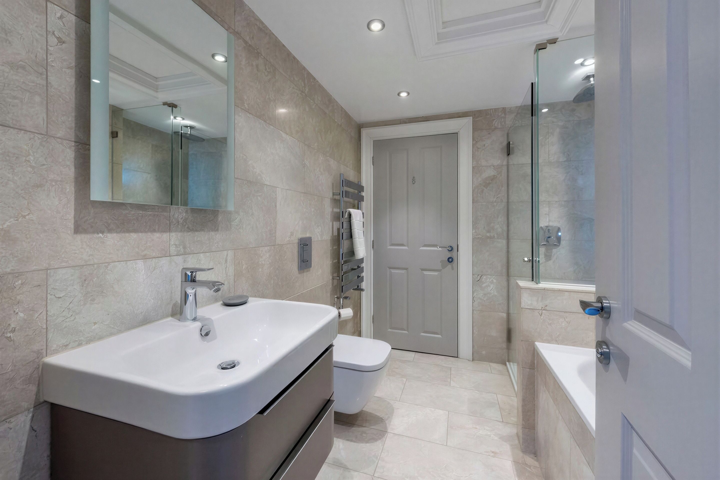 Un bagno moderno con lavandino, WC e zona doccia.