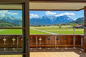 A wooden balcony with a view of a mountain landscape. - WeitBlick Zugspitze – Alpine Design & Panoramic Views for 4 People (Farchant)