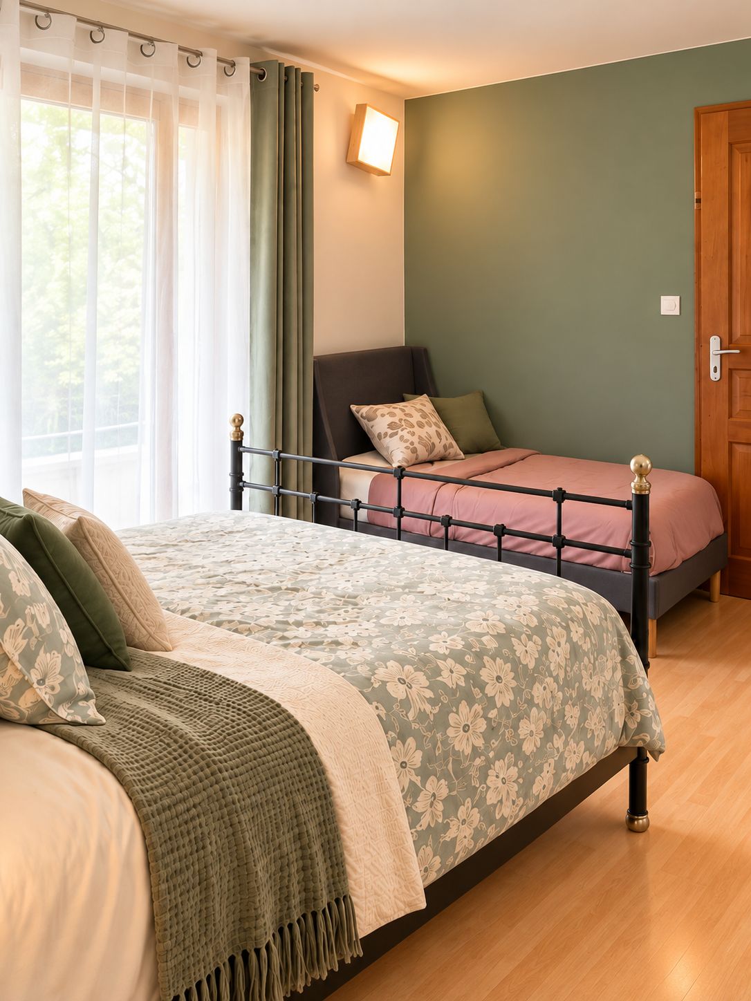A bedroom with a double bed, a bedside table, a nightstand, a window with curtains, and a wall-mounted light.