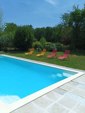 A swimming pool with a tiled deck and four lounge chairs. - A cozy little nest surrounded by lush greenery—sleeps 4 (Caussade)