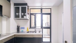 Una cocina moderna con una isla central, lavaplatos doble y vistas al exterior a través de un ventanal.