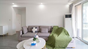 Una sala de estar moderna con un sofá, una mesa de centro y una manta verde.