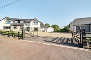 A residential area with houses, a gated driveway, and a gravel path.