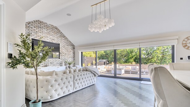 A modern living room with a brick fireplace, a large sectional sofa, and a dining area. - Rochester Retreat, Spacious 5 Bedroom House (Rochester)