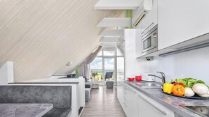 Eine moderne Küche mit Einbauofen, Spüle und Essbereich mit Blick.