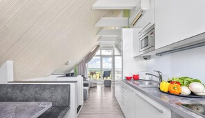 Eine moderne Küche mit Einbauofen, Spüle und Essbereich mit Blick.