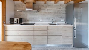 A modern kitchen with a built-in microwave, stainless steel sink, and a refrigerator. - VERY QUIET COUNTRY HOUSE NEAR INCA (Inca)
