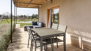 A covered patio with a table and chairs, a sofa with cushions, and a view of the outdoors. - VERY QUIET COUNTRY HOUSE NEAR INCA (Inca)