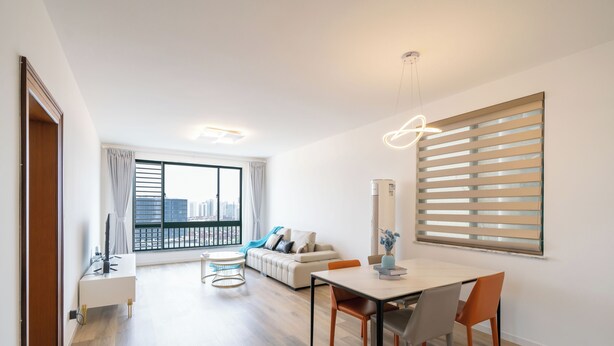 A modern living room with a dining area, large windows, and a city view. - Tyms 2BR 1BA Family Serviced Residence (Shanghai)