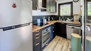 A compact kitchen with a refrigerator, microwave, oven, and sink. - Villa lake view, pets welcome - 6 guests (Soustons)